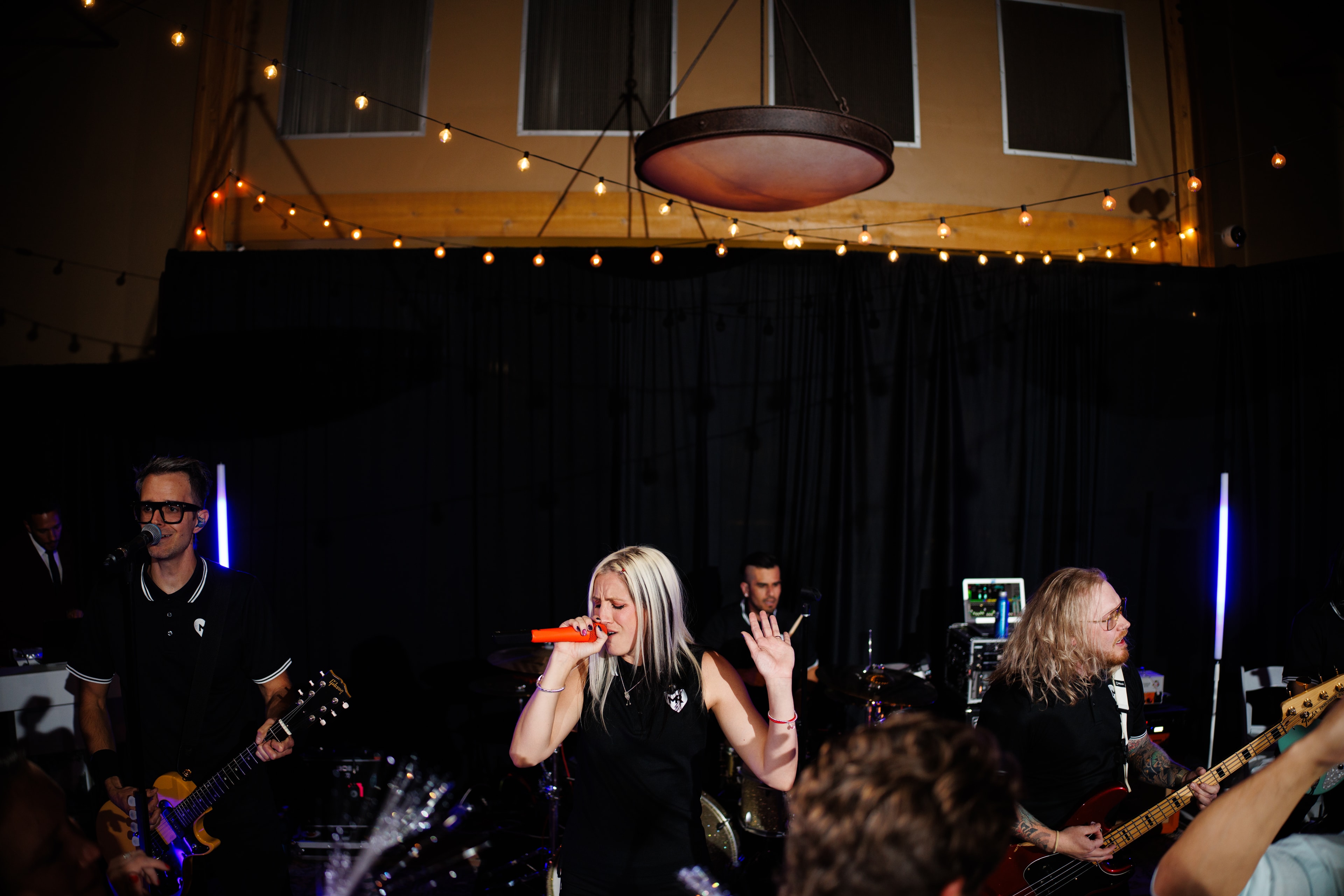 Millennial Romance performing on stage with string lights